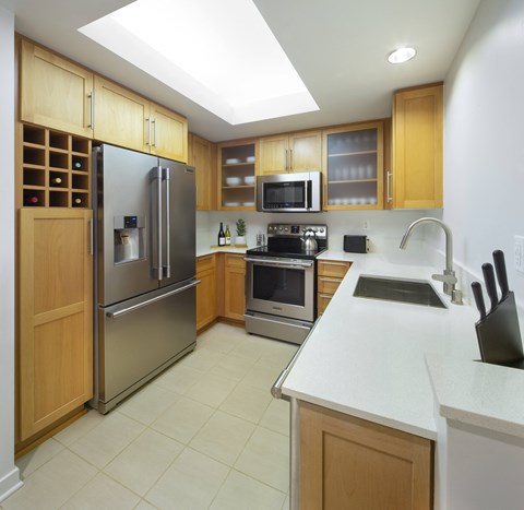 a modern kitchen with stainless steel appliances and wooden cabinets
